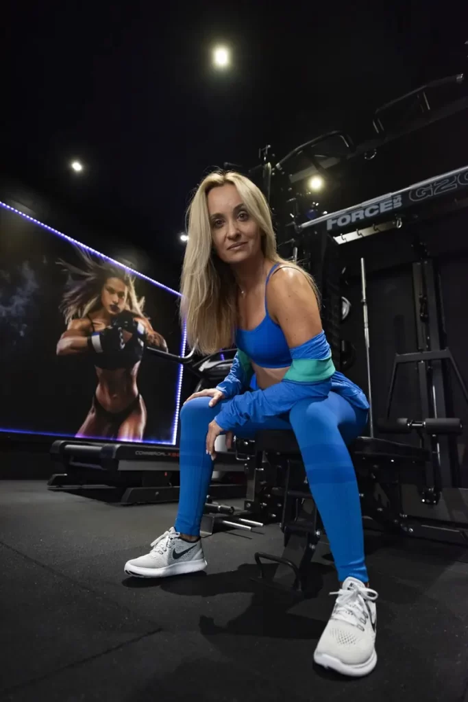 Female personal trainer in Bromley sitting in private gym with strength equipment and one-to-one coaching environment